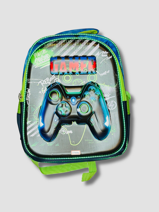 Front view of a kids’ backpack with a 3D game controller design, “GAMER” text, and graffiti-style graphics on a black and green background.